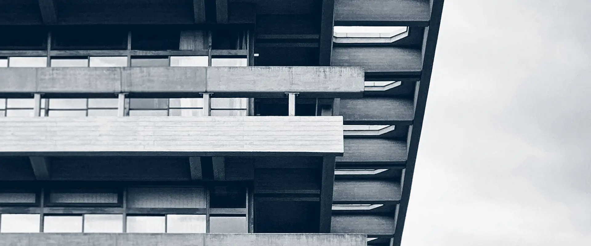 A long building elevation of stacked horizontal balconies and fins, seen along its length.