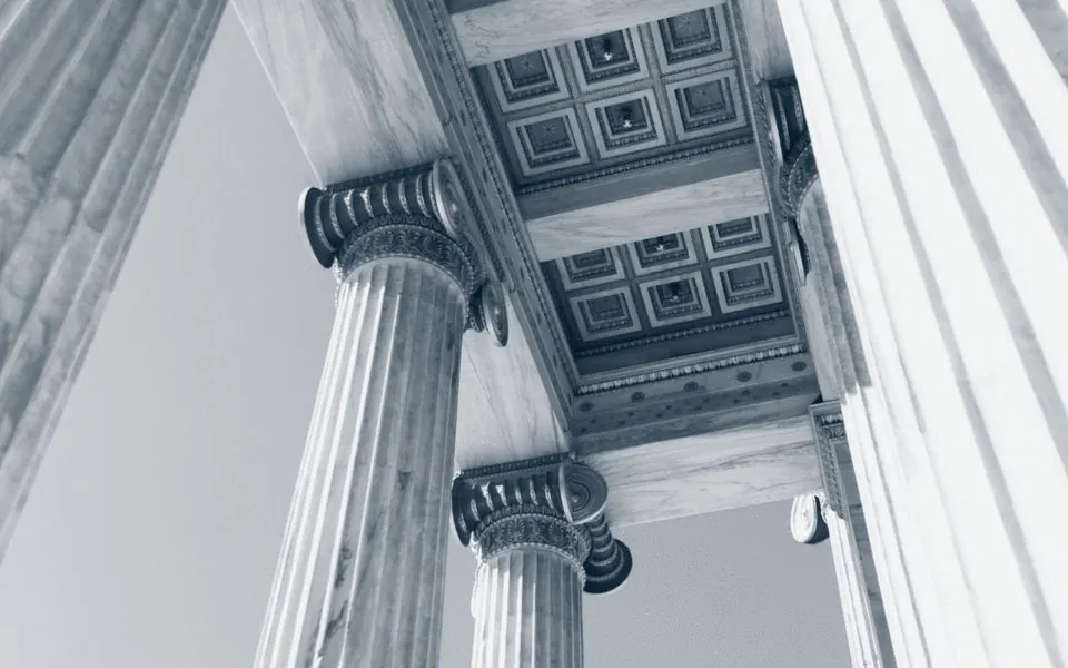 Stone columns carrying a coffered ceiling, photographed from below.