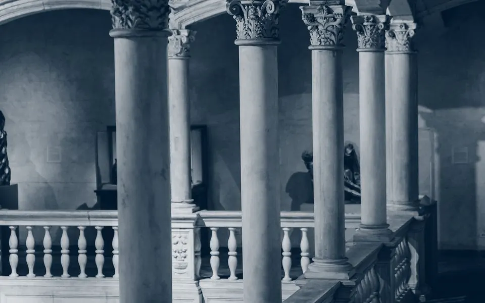 A stone corridor lined with pillars, receding into shadow.
